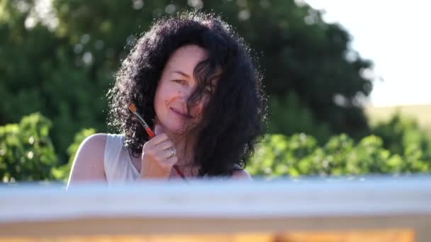 Artista femenina pintando una pintura colorida al aire libre — Vídeos de Stock