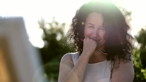 Artista femenina pintando una pintura colorida al aire libre — Vídeos de Stock