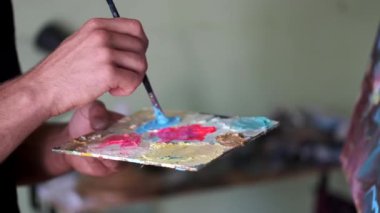 sanatçı karıştırma ve boya karıştırarak boya hazırlanıyor
