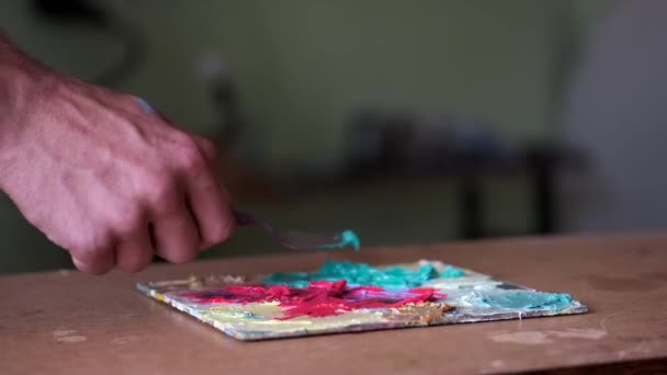 Künstler macht sich bereit, durch Mischen und Mischen von Farbe zu malen — Stockvideo