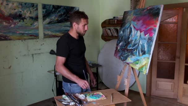 Artiste masculin peignant une image dans un studio — Video