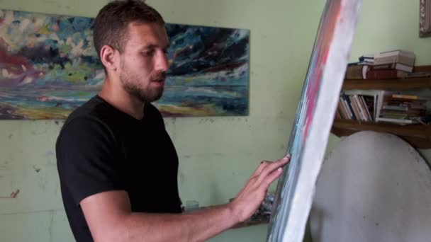 Artista masculino pintando un cuadro en un estudio — Vídeo de stock