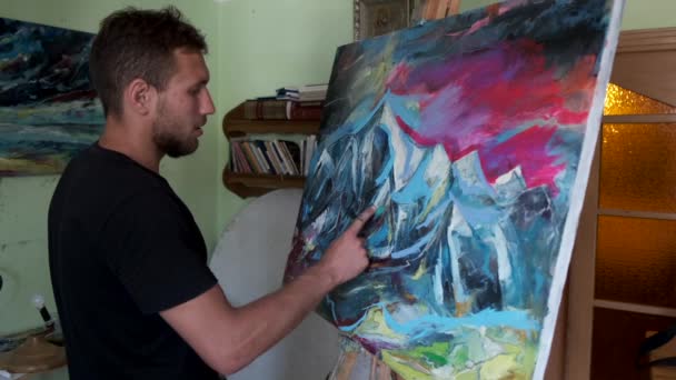 Artista masculino pintando un cuadro en un estudio — Vídeos de Stock