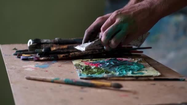 Художник готовится к рисованию, смешивая и смешивая краску — стоковое видео