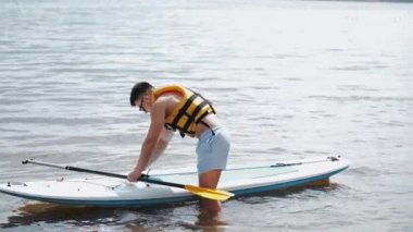 göl üzerinde dışında fit adam paddleboarding