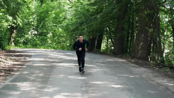 Hombre en forma corriendo afuera en el parque — Vídeo de stock