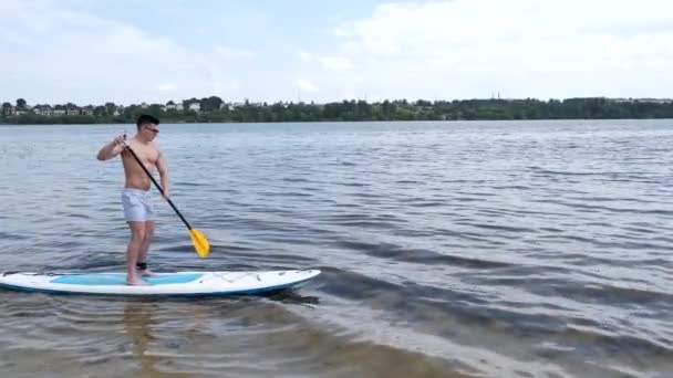 Pria fit paddleboarding luar danau — Stok Video