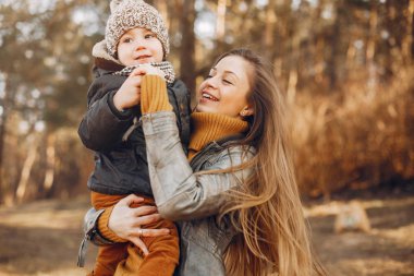 Anne ve oğlu yaz parkında oynuyorlar.