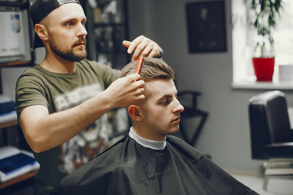 Un hombre corta el pelo en una barbería —  Fotos de Stock
