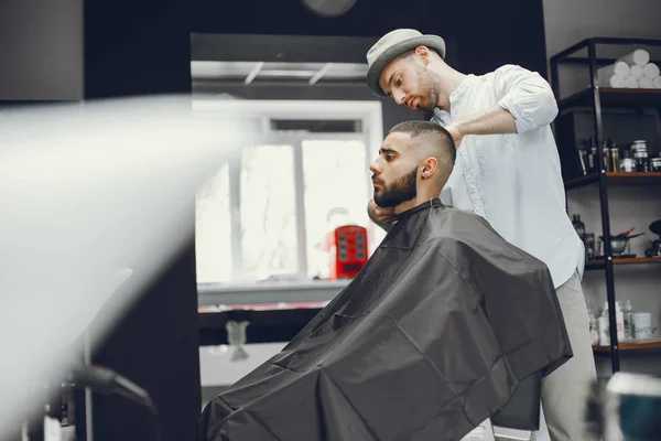 Un hombre corta el pelo en una barbería —  Fotos de Stock