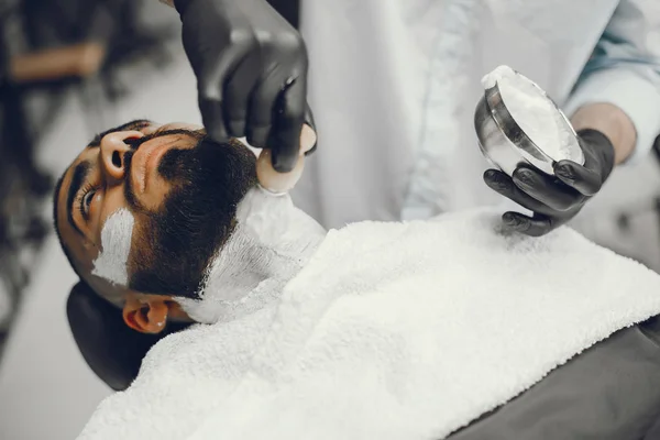 O homem corta a barba na barbearia — Fotografia de Stock