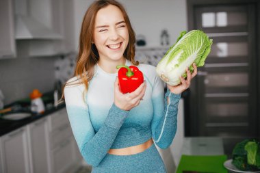 Spor kız sebze ile mutfakta