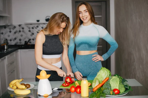 Deux sportives dans une cuisine avec des légumes — Photo