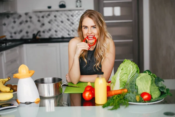 Sportovní dívka v kuchyni se zeleninou — Stock fotografie