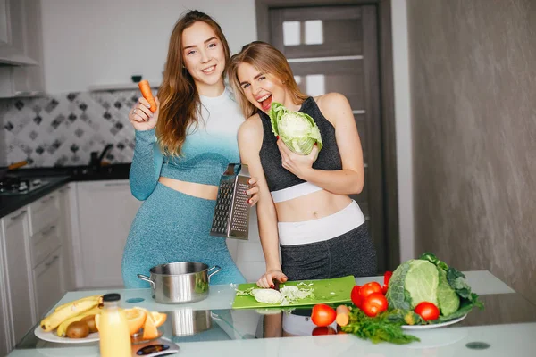 Deux sportives dans une cuisine avec des légumes — Photo