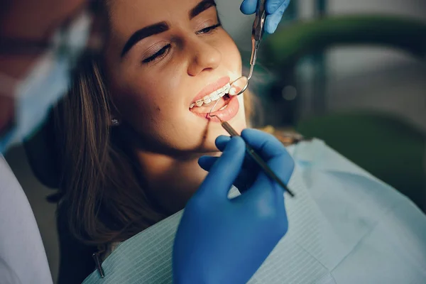 Kaunis tyttö istuu hammaslääkärin toimistossa — kuvapankkivalokuva
