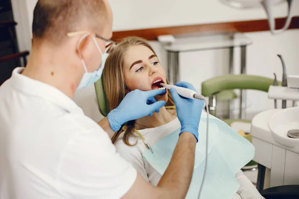 Schöne Mädchen sitzen in der Zahnarztpraxis — Stockfoto