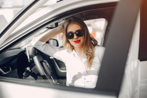 Mujer con estilo en un salón de coches — Foto de Stock
