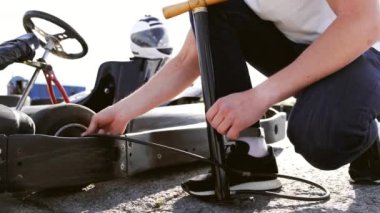 çekici adam onun gocart üzerinde lastik basıncı kontrol
