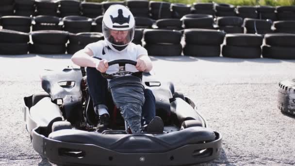 Homem atraente sititng em um gocart na pista — Vídeo de Stock