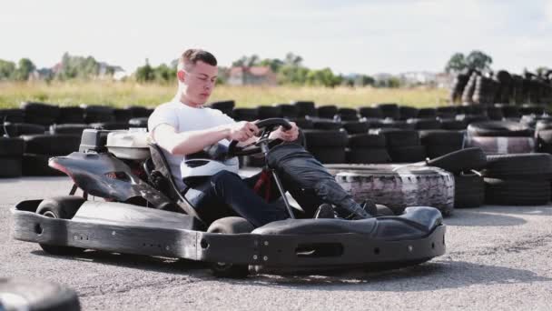 Attractive man sititng in a gocart on the track — Stock Video
