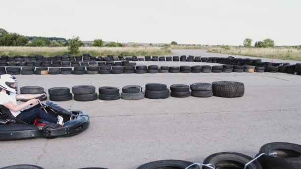 Corredor masculino en carreras de casco protector en la pista de karts al aire libre — Vídeo de stock