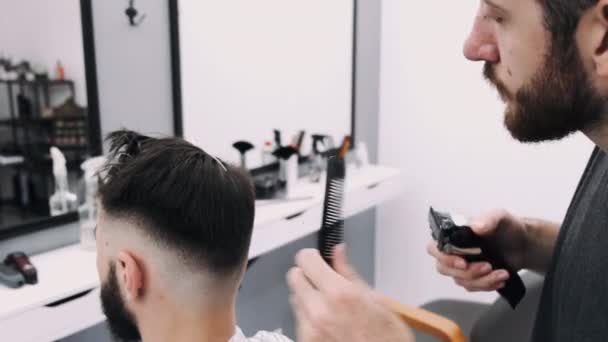 Чоловік отримує зачіску від перукаря — стокове відео