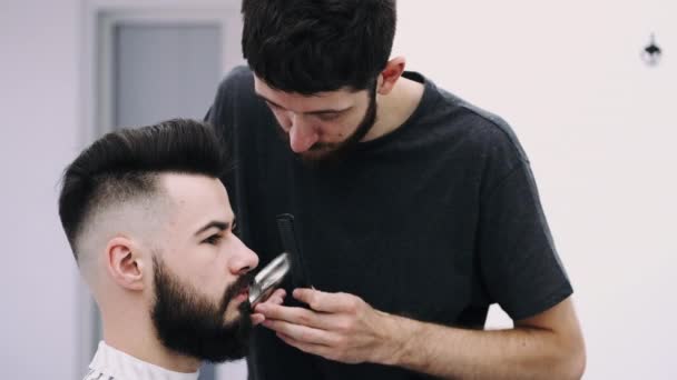 Man får en frisyr från en barberare — Stockvideo