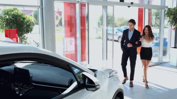 Casal entrando em uma concessionária de carro para comprar um carro — Vídeo de Stock