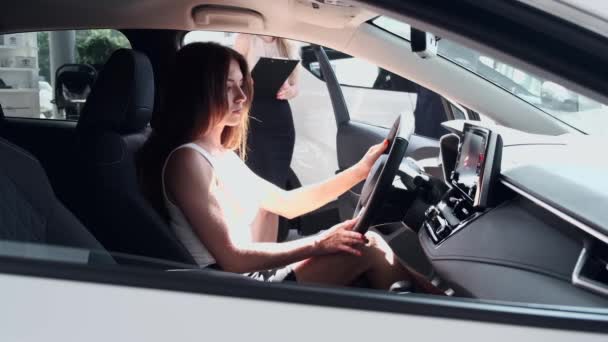 Elegante Frau testet Autofahren im Autohaus — Stockvideo