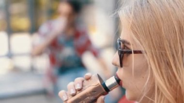 Şehirde şık bir çift var. İki kişi elektronik sigara kullanıyor.