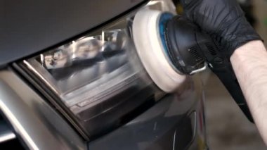 Adam garajda araba cilalıyor.