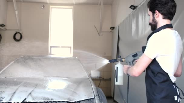 Мужчина моет машину в гараже — стоковое видео