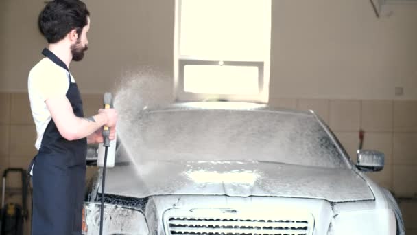 Мужчина моет машину в гараже — стоковое видео