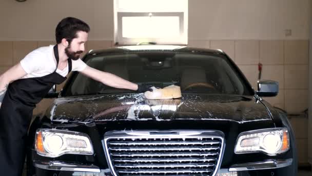 Człowiek mycie samochodu w garażu — Wideo stockowe