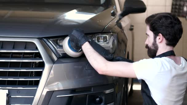 Hombre pulir un coche en un garaje — Vídeo de stock