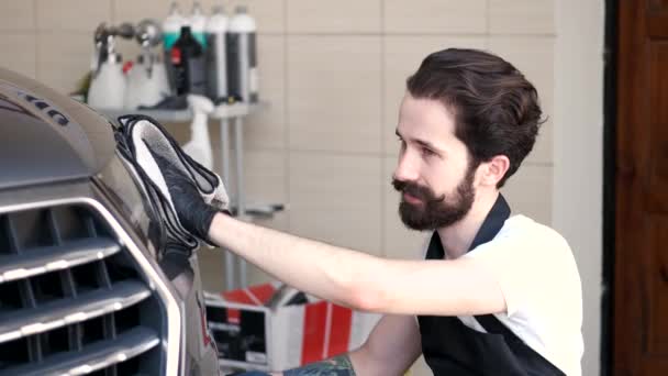 Ο άνθρωπος σκουπίζει ένα αυτοκίνητο σε ένα γκαράζ — Αρχείο Βίντεο