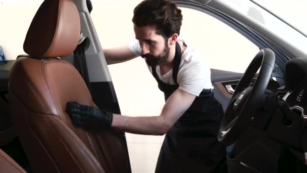 Чоловік миє машину в гаражі — стокове відео