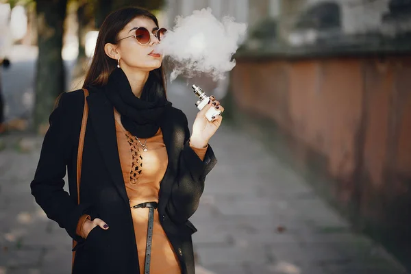 Stylowa dziewczyna palenie e-papierosa — Zdjęcie stockowe