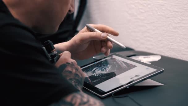 Artista del tatuaje trazando la imagen para el nuevo tatuajeen el estudio — Vídeo de stock