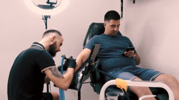 Manlig tatuering konstnär tatuera en kund — Stockvideo