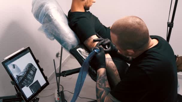 Татуировщик мужского пола, татуирующий клиента — стоковое видео
