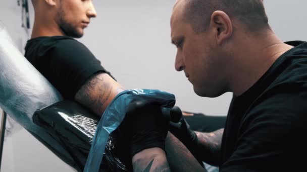 Mannelijke Tattoo kunstenaar tatoeëren een cliënt — Stockvideo