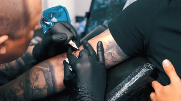 Tatoueur masculin tatouant un client — Video