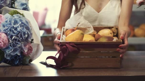 Ανθοπώλης φτιάχνοντας ένα καλάθι φρούτων για έναν πελάτη ως δώρο — Αρχείο Βίντεο