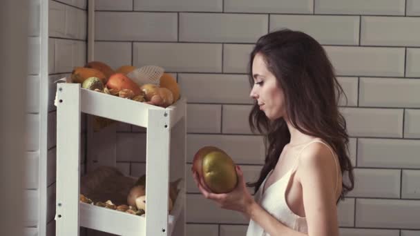 Hermosa mujer recogiendo fruta de un refugio para una cesta de frutas — Vídeo de stock