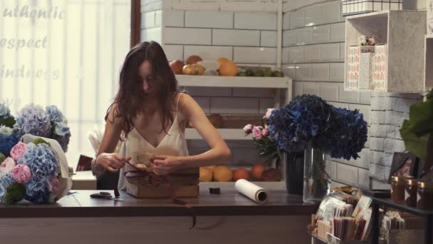 Floristería haciendo una cesta de frutas para un cliente como regalo — Vídeos de Stock