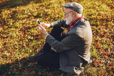 Güneşli bir sonbahar parkta zarif yaşlı adam