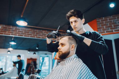 Berber dükkanında oturan şık bir adam.