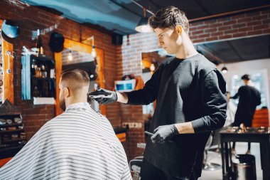 Berber dükkanında oturan şık bir adam.